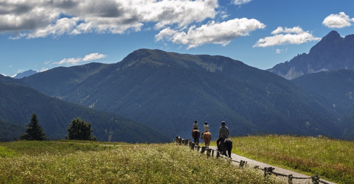 three people ride over the mountains 