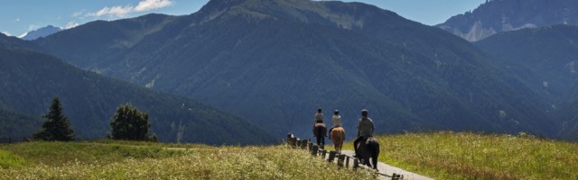 three people ride over the mountains 